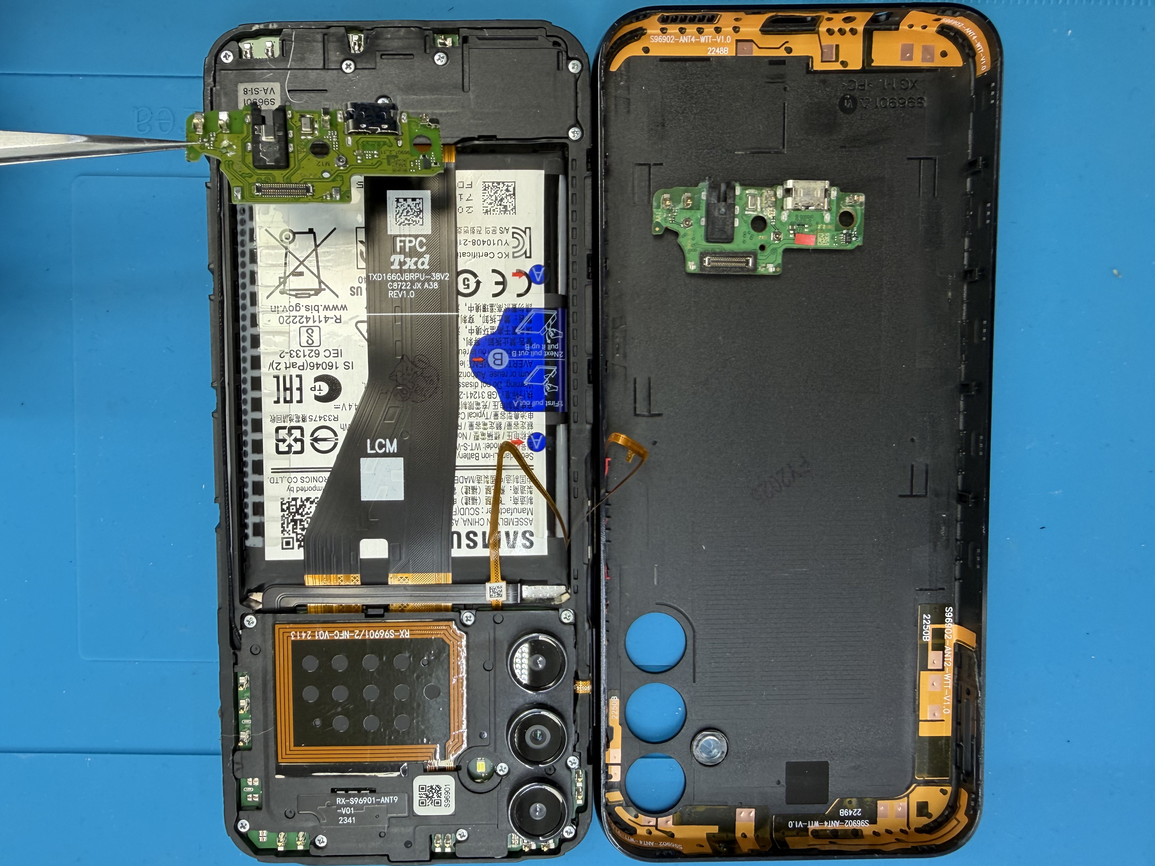 Samsung Galaxy battery and screen repair parts on a repair mat at Electronics Garden Repair